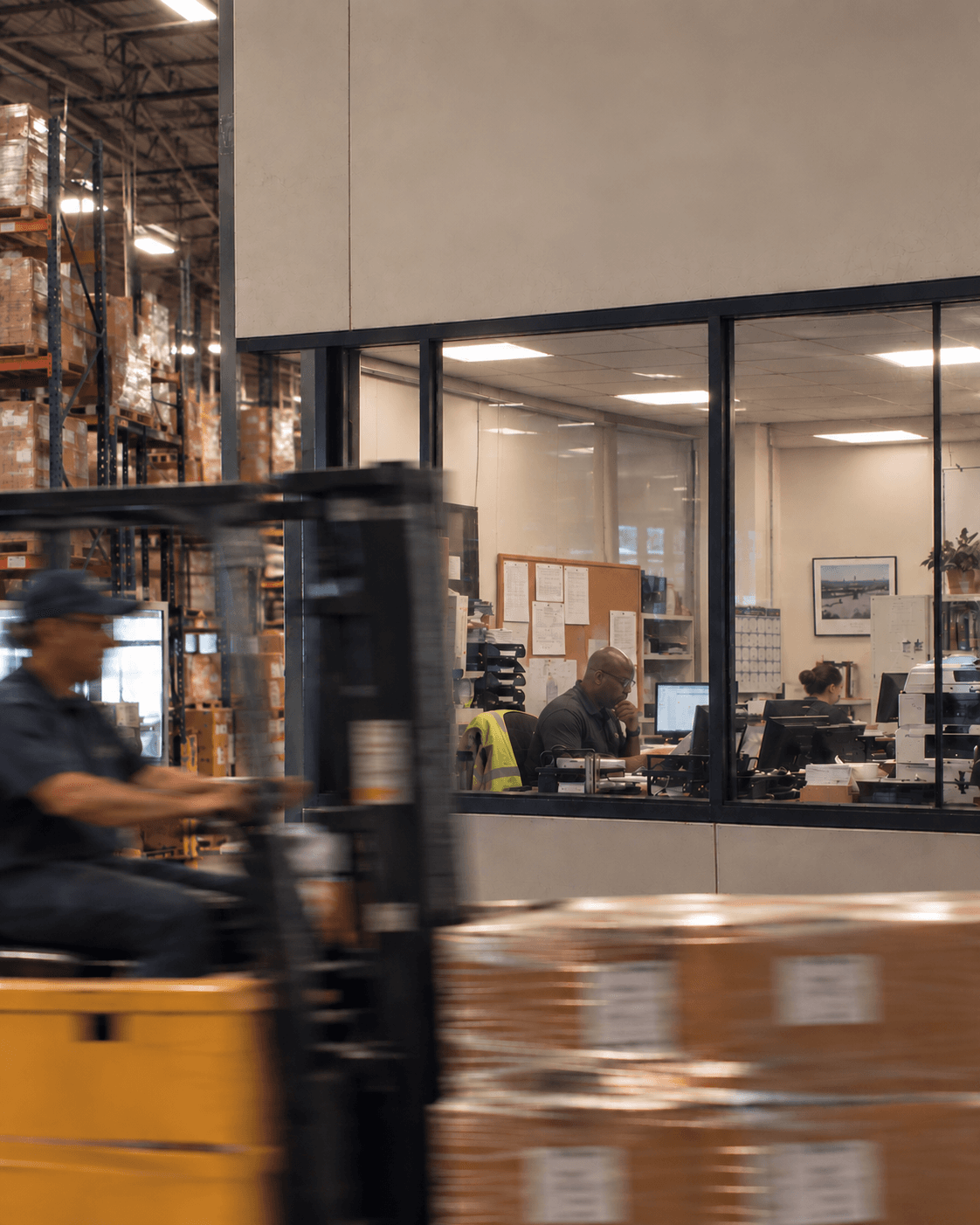 Warehouse operations office with a forklift passing