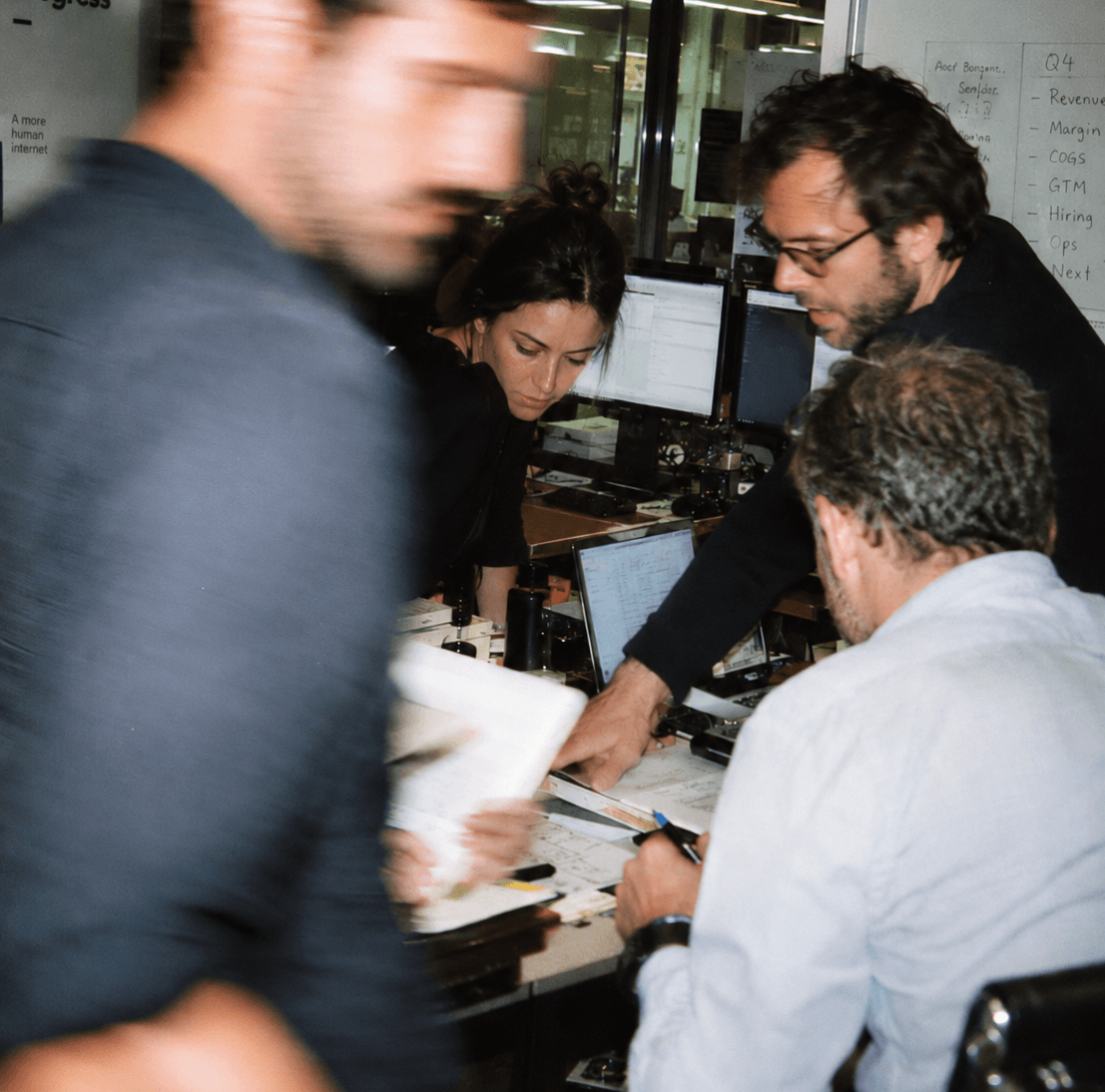A team working together over paperwork and screens