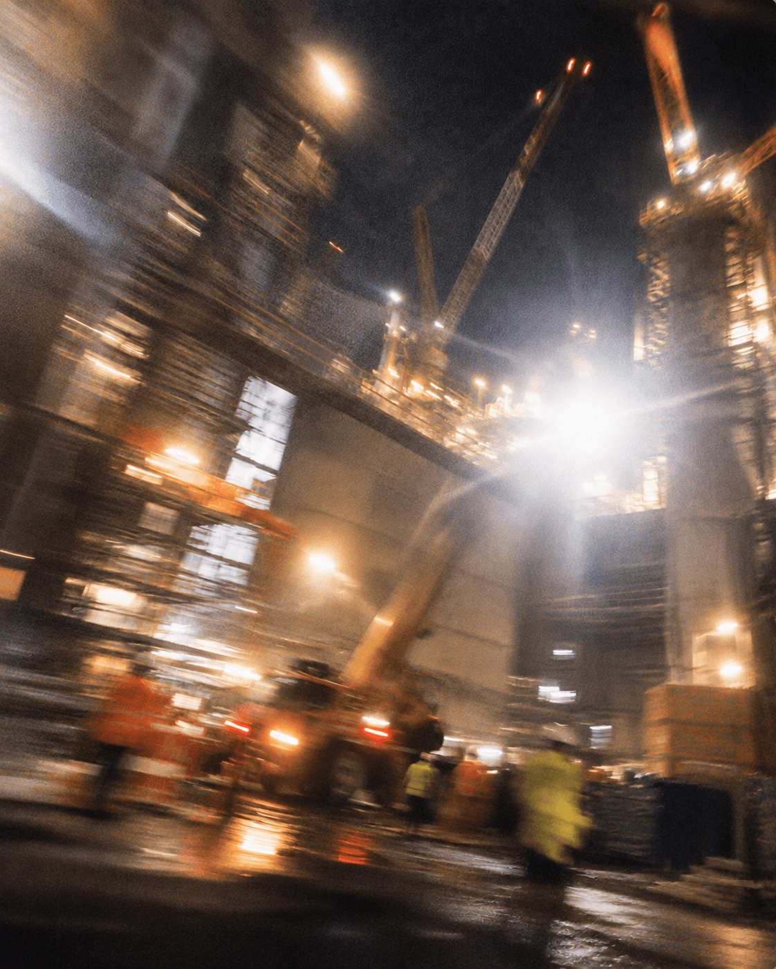 Night construction site with cranes and working lights